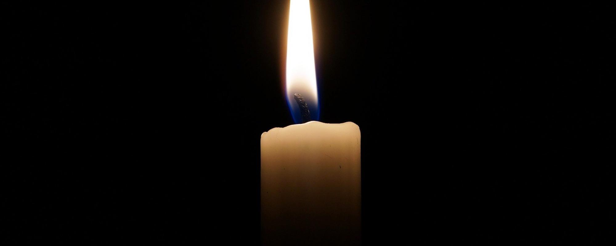 Dark background with a single lit candle