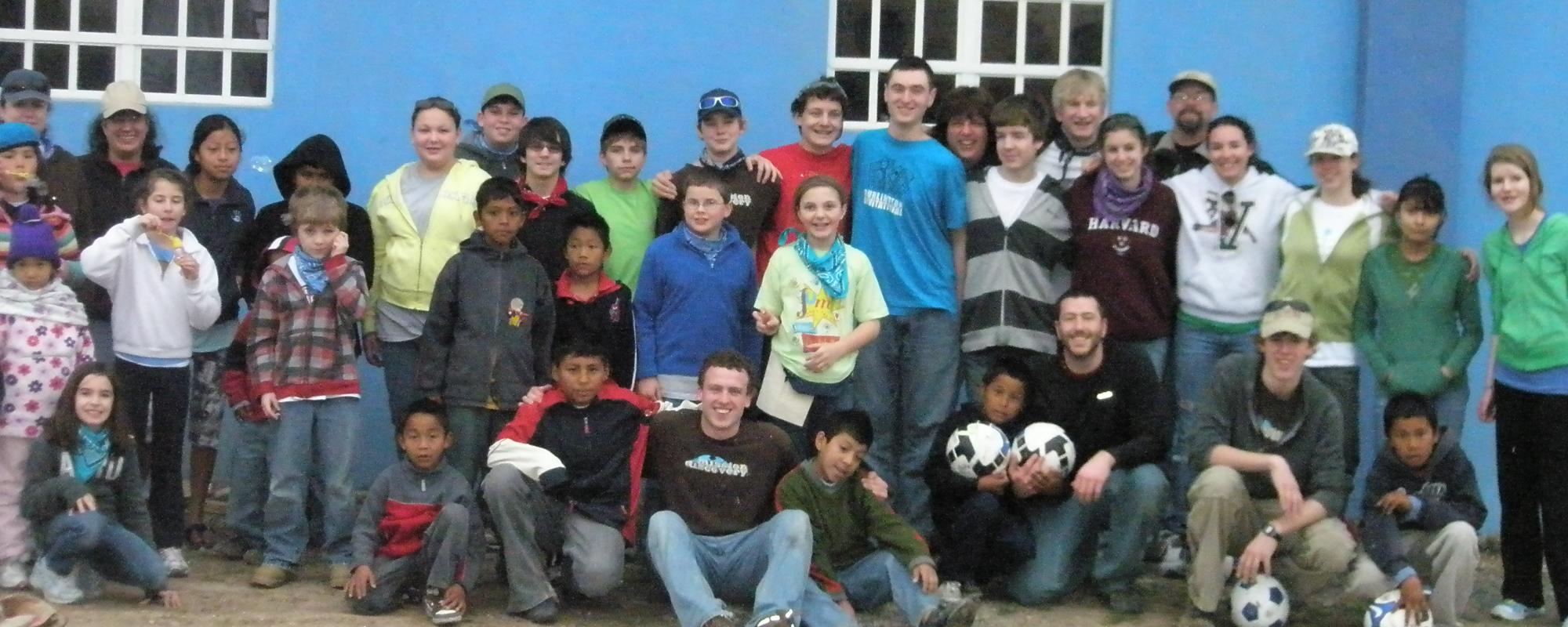 group of volunteers and kids with soccer balls